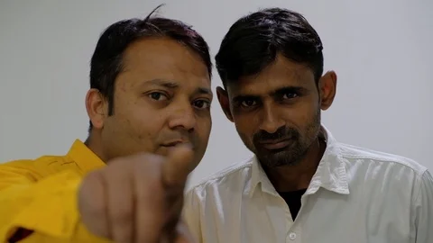 Two coworkers look deeply at camera POV share and discuss and make hand gestures Stock Footage 100026612