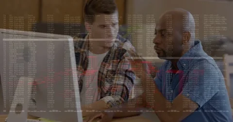Two coworkers sitting at table, left man typing and bringing terminal overlay on Stock Footage 334185229