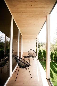Two cozy comfortable designer straw chairs with cushions stand on a open loggia Stock Photos