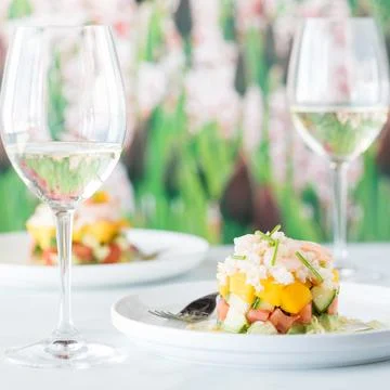 Two crab stack salads served with white wine against a soft focus background. 스톡 사진