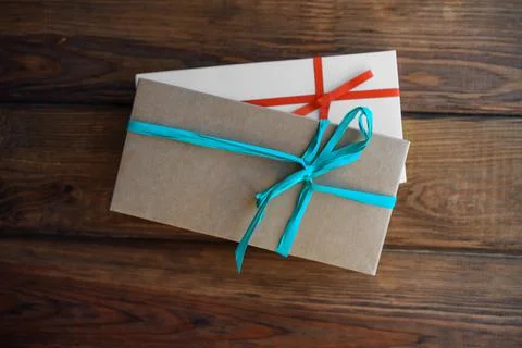 Two craft boxes of natural materials with bows on a wooden background Stock Photos