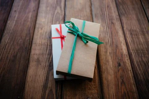 Two craft boxes of natural materials with bows on a wooden background Stock Photos