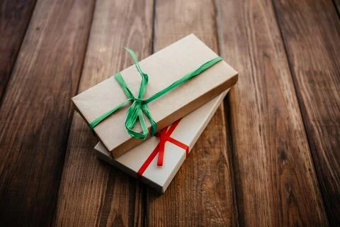 Two craft boxes of natural materials with bows on a wooden background Stock Photos