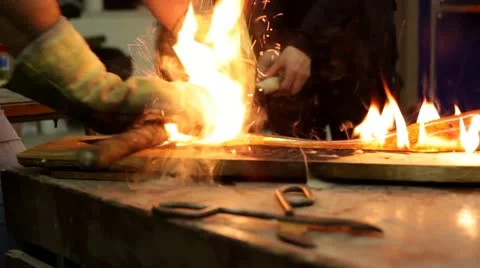 Two craftsman working as a team with molten glass. Hands in fire. Stock Footage 21639230