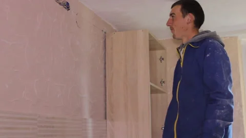 Two craftsmen install a hanging kitchen cabinet Stock-Footage 329238782