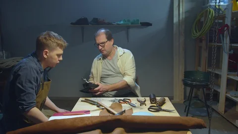 Two craftsmen make shoes. Learning process. Quarantine Stock Footage 127833373