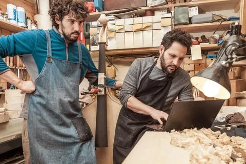 Two craftsmen violinmakers checking a new violin Stock Photos