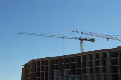 Two cranes on a blue sky background Stock Photos