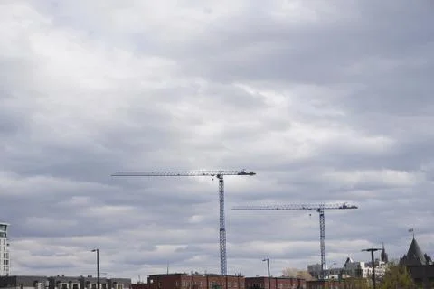 Two cranes under a cloudy sky. Фото