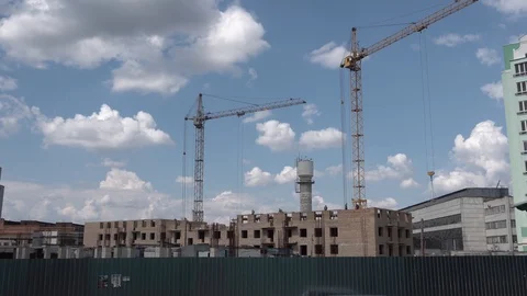 Two cranes working on the building territory. Builders working on the roof Stock Footage 129792891