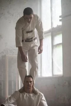 Two crazy men in straitjackets are in an abandoned clinic Stock Photos