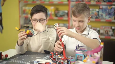 Two creative boys build from the cubes of the designer various objects Stock Footage 87958481