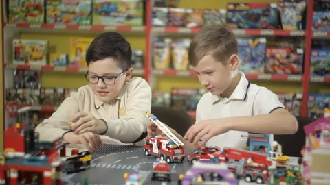Two creative boys build from the cubes of the designer various objects Stock Footage 87958813