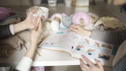 Two creative woman friends using book with knitting pattern. Knitting hands Stock Footage 87063061