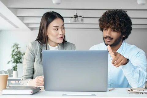 Two creative workers discussing online startup project looking at laptop screen Stock Photos