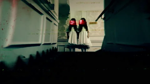 Two creepy twins with red distorted faces standing on hotel stairs, horror Stock Footage 155454267