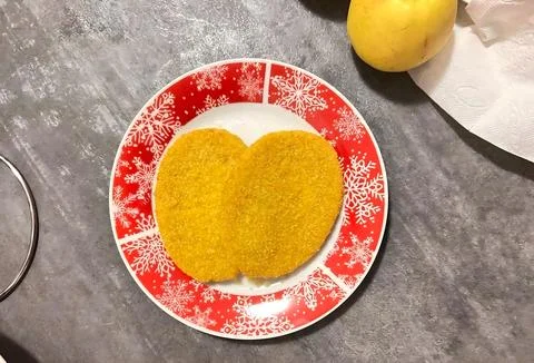 Two Crispy Breaded Chicken Cutlets on a Festive Red Snowflake Plate Stock Photos