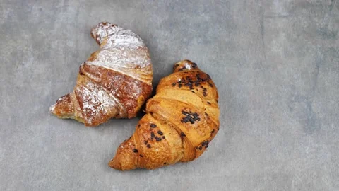 Two croissants rotating on a gray background, top view Stock Footage 219225255