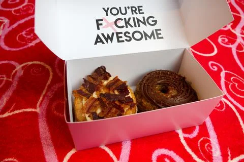 Two cronuts in a paper box on a red background. Foto stock