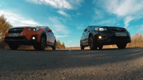 Two crossovers driving down the autumn road Vídeos de archivo 163924497