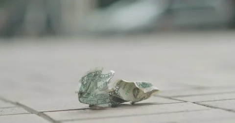 Two crumpled dollar roll on street Stock Footage
