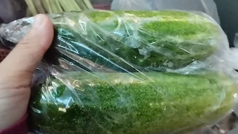 Two cucumbers in plastic wrap for sale Stock Footage 229554290