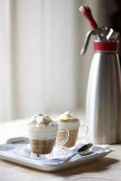 Two cup of coffee cream on the table near a  kitchen siphon Stock Photos