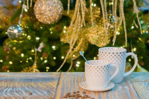 Two cup on rustic table with christmas decorated tree blurred background Stock Photos