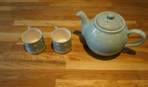 Two cups and a tea pot on a wooden background 库存照片