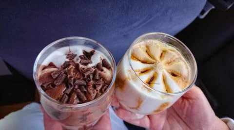 Two cups of appetizing ice cream in hand Stock Photos