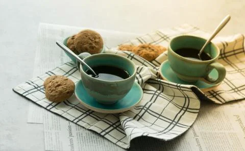 Two cups of black coffe with spoon on supported dish on fabric Stock Photos