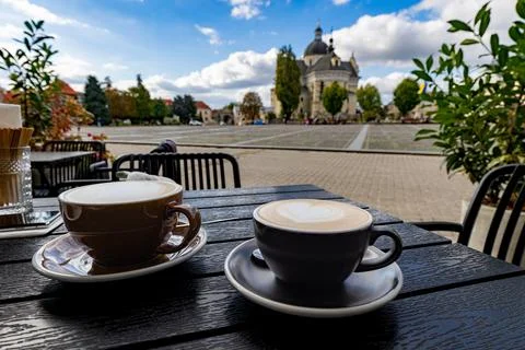 Two cups of cappuccino on cafe table with Zhovkva city square view Stock Photos