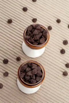 Two cups of chocolate chips with strayed chips on the side Stock Photos
