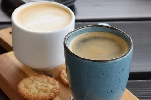 Two cups of coffee and a cookie as a close up Stock Photos
