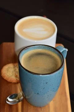 Two cups of coffee and a cookie as a close up Stock Photos
