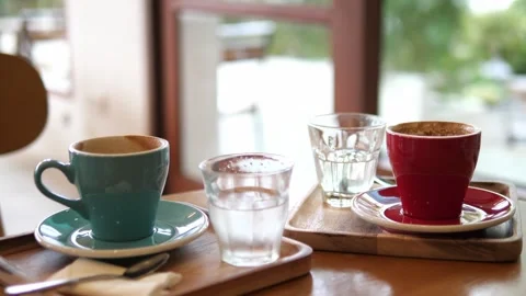 Two Cups of Coffee and Water on Wooden Tray in Cozy Café. Stock-Footage 322007097
