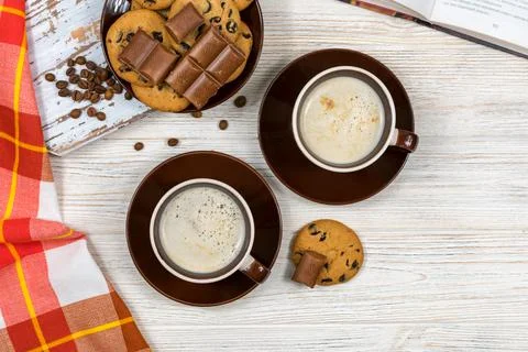 Two cups of coffee with chocolate chip cookies and chocolate on the background Stock Photos