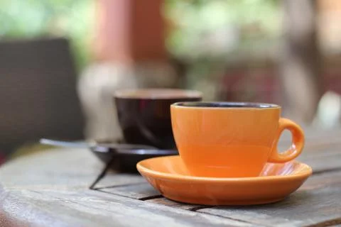 Two cups of coffee stand on a table outside, breakfast, morning coffee. Cer.. Stock Photos