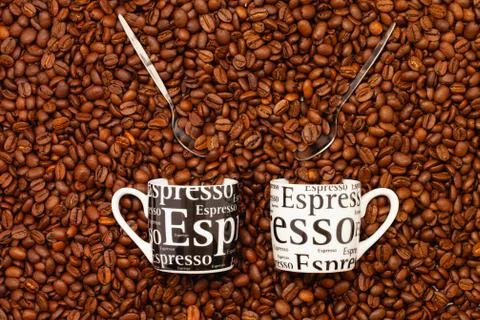 Two Cups of coffee on a table full of coffee beans. Photos