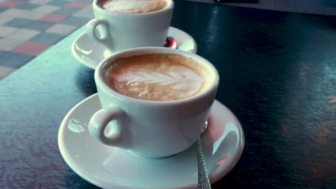 Two cups of coffee on the table, latte art Stock Footage 142472680