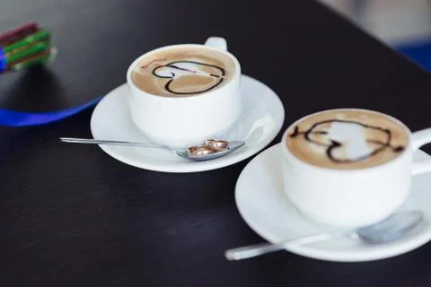 Two cups of coffee on the table with wedding rings Stock Photos