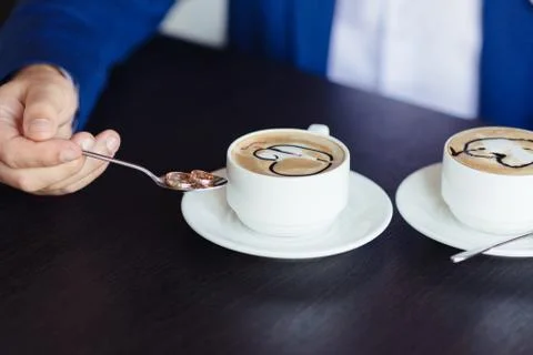 Two cups of coffee on the table with wedding rings Stock Photos
