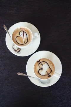 Two cups of coffee on the table with wedding rings Stock Photos