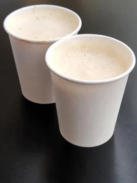 Two cups of coffee. Two paper glasses with coffee on a black background Stock Photos