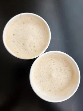 Two cups of coffee. Two paper glasses with coffee on a black background Stock Photos