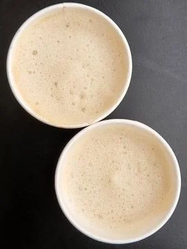 Two cups of coffee. Two paper glasses with coffee on a black background Stock Photos