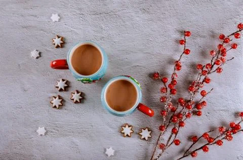 Two cups of coffee on white table with red berry branch. Stock Photos