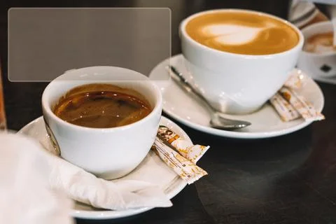 Two cups of different coffee on rustic wooden table. Symbolic image. Copy space Fotos Stock