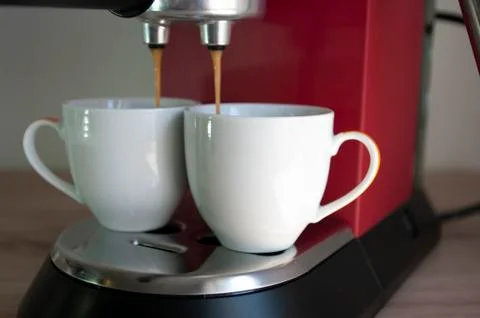 Two cups of espresso, preparing coffee process, red coffee machine. Stock Photos