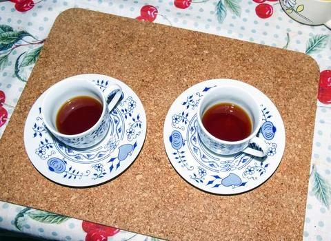 Two Cups of Fresh Black Coffee on Cork Table Mat Stock Photos